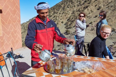 Foto de Atlas Mountains, Morocco - 04 th February, 2017: Man preparing tea. Morocco is famous of it's mint tea. Morocco - Imagen libre de derechos