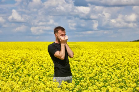 Photo for Man in field blowing his nose and suffering from hay fever. Allergy - Royalty Free Image