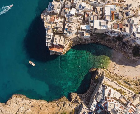 Photo for People bathing in the sun in Blue Lagoon, Polignano a Mare the beach. Aerial view of swimming in beautiful clear sea water. Transparent water.Top view from flying drone.Travel - Royalty Free Image