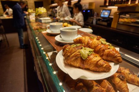 Photo for French baked croissants sprinkled with icing or powered sugar on wooded table background. Eating croissant with tea in cafe is healthy. Croissant is pastry served in cafe. Healthy lifestyle concept. - Royalty Free Image