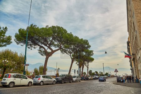 Photo for Naples, Italy - October 24, 2019: Cars on the street and ancient red building next to the embankment of Naples. Campania, Italy. - Royalty Free Image