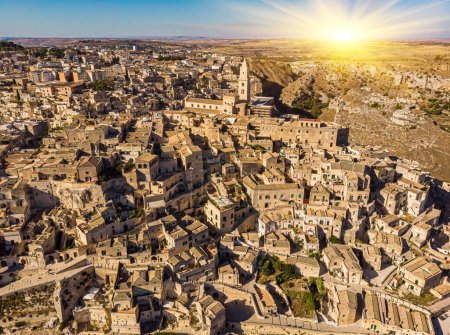 Photo for Aerial view of medieval city of Matera Sassi di Matera in beautiful golden morning light at sunrise. Birds view of Sassi di Matera, in Basilicata, southern Italy, and is an Unesco world heritage. - Royalty Free Image
