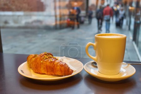 Photo for French baked croissant sprinkled with icing or powered sugar on wooded table background. Eating croissant with tea in caf is healthy. Croissant is pastry served in caf. Healthy lifestyle concept. - Royalty Free Image