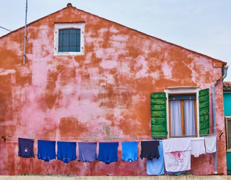 Téléchargez les photos : Blanchisserie mise à sécher sur un petit endroit traditionnel et très coloré sur l'île de Burano, Italie. - en image libre de droit