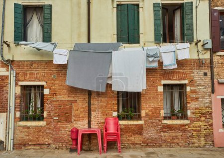 Foto de Esquina típica de la ciudad con antiguo edificio colorido secando la ropa en una línea de ropa al aire libre en el día de verano soleado. Venecia, Italia - Imagen libre de derechos