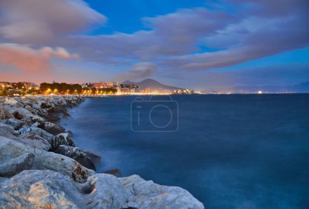 Foto de Castel dell Ovo Egg castillo en Nápoles, Italia, vista desde el muelle de la playa en la luz azul de la noche - Imagen libre de derechos