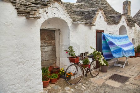 Téléchargez les photos : Alberobello, Pouilles, Italie : Paysage urbain à vélo près de vieilles maisons de cette région, Pouilles - en image libre de droit