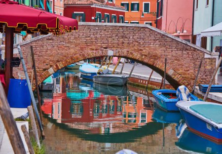 Foto de Colorida arquitectura y canal con barcos en Burano Island, Venecia, Italia. Famoso destino de viaje. Hermoso paisaje urbano europeo - Imagen libre de derechos