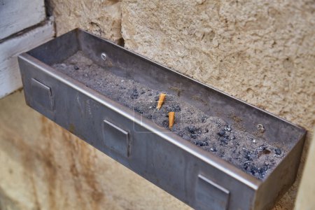 Téléchargez les photos : Les mégots de cigarette jetés dans le cendrier dans le hall de l'hôtel en Italie. - en image libre de droit