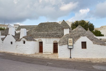 Téléchargez les photos : Alberobello, Pouilles, Italie : Maisons typiques construites avec des murs en pierre sèche et des toits coniques du Trulli, dans une belle journée, Pouilles - en image libre de droit