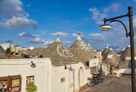 Téléchargez les photos : Alberobello, Pouilles, Italie : Maisons typiques construites avec des murs en pierre sèche et des toits coniques du Trulli, dans une belle journée, Pouilles - en image libre de droit