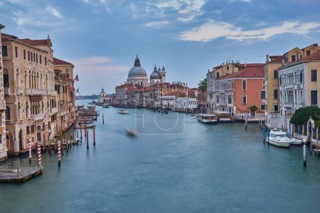 Téléchargez les photos : Ancien canal avec pont, gondole, maisons, fleurs par temps nuageux.Venise Italie - en image libre de droit