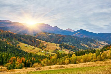 Foto de Una impresionante vista de una mañana de otoño en las montañas: un pueblo rural descansando en un valle en medio de un escenario de pinos y bosques mixtos - Imagen libre de derechos