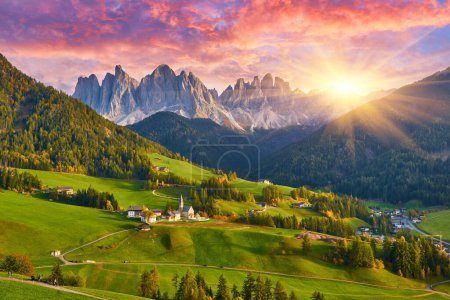 Téléchargez les photos : Superbe paysage d'automne dans le village de Santa Maddalena avec église, arbres colorés et prairies sous les rayons du soleil levant. Dolomite Alpes, Tyrol du Sud, Italie. - en image libre de droit