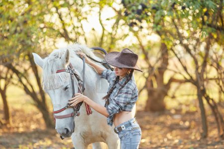 Foto de Retrato de joven vaquera y caballo al aire libre - Imagen libre de derechos