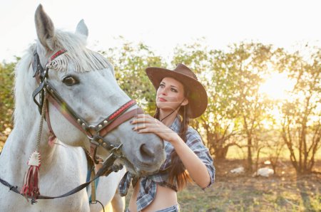 Foto de Feliz vaquera con sombrero abrazando a su caballo - Imagen libre de derechos