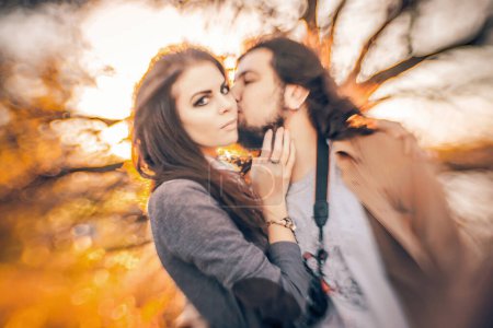 Foto de Pareja profundamente enamorada comparte un tierno beso en el telón de fondo del otoño. - Imagen libre de derechos