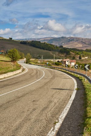 Foto de Carreteras del sur de Italia Puglia con el paisaje de colinas, campos y turbinas eólicas. - Imagen libre de derechos