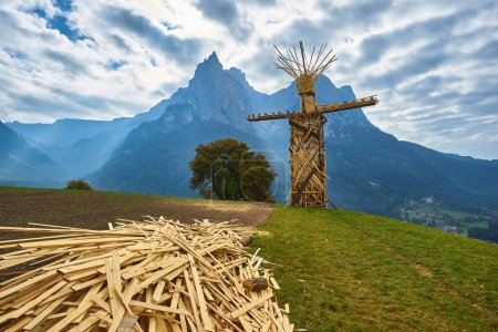 Téléchargez les photos : Statue of a wooden Burning man above the Catinaccio Group, seen by Pozza di Fassa in the Dolomites mountain range, Italy. - en image libre de droit