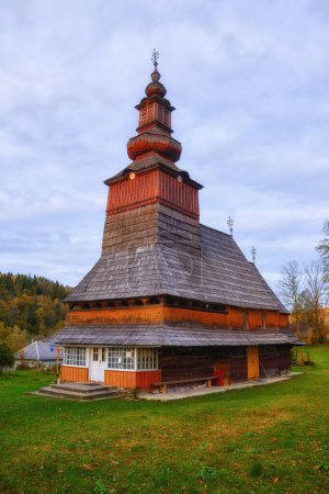 Foto de Belleza de una iglesia de madera serena enclavada en un pintoresco pueblo en el oeste de Ucrania. - Imagen libre de derechos