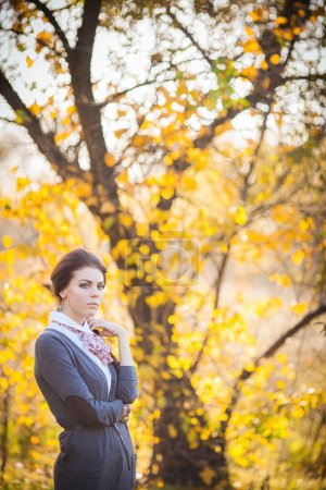 Photo for Captured amidst the mesmerizing beauty of the autumn forest, a graceful brunette girl radiates with elegance and serenity. The vibrant colors of the falling leaves and dappled sunlight create a captivating backdrop for her presence. - Royalty Free Image