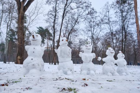 Téléchargez les photos : Une scène hivernale mettant en vedette cinq petits bonhommes de neige debout dans un parc. - en image libre de droit