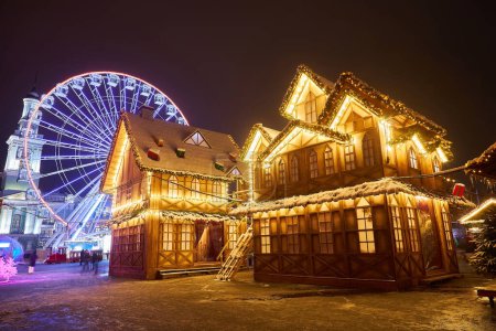 Téléchargez les photos : Marché de Noël avec arbre du Nouvel An à Kiev, Ukraine. La grande roue et la décoration de Noël à la place Kontraktova sur Podil. - en image libre de droit