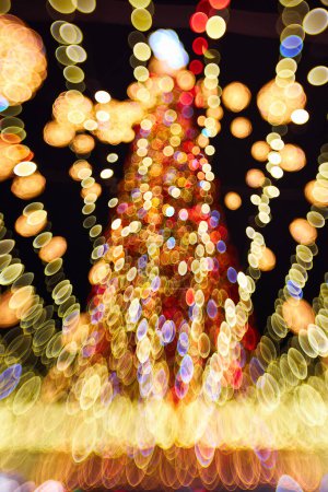 Foto de Navidad y feliz año nuevo borrosa bokeh. Auténtica toma de luz colorida en el árbol de navidad al aire libre con bokeh. Hermosa Navidad fondo bokeh - Imagen libre de derechos