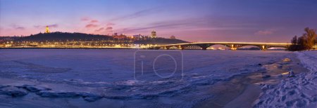 Téléchargez les photos : Embrassant l'enchantement de l'hiver, cette photo capture la beauté sereine de la rivière gelée Dnipro à Kiev, avec l'emblématique lavra de Kiev Pechersk à l'horizon. - en image libre de droit