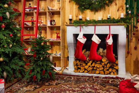 Téléchargez les photos : Cheminée décorée à l'intérieur de la pièce la veille de Noël - en image libre de droit