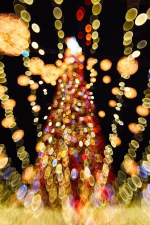 Foto de Navidad y feliz año nuevo borrosa bokeh. Auténtica toma de luz colorida en el árbol de navidad al aire libre con bokeh. Hermosa Navidad fondo bokeh - Imagen libre de derechos