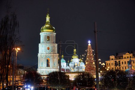Téléchargez les photos : Arbre de Noël avec des lumières à l'extérieur la nuit à Kiev. Cathédrale de Sophia sur fond. Célébration du Nouvel An - en image libre de droit