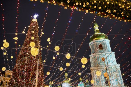 Foto de Árbol de Navidad con luces al aire libre por la noche en Kiev. Catedral de Sofía en el fondo. Celebración de Año Nuevo - Imagen libre de derechos