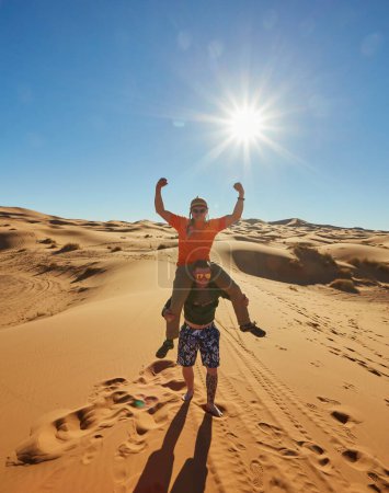 Foto de Un animado grupo de turistas captura momentos en el desierto del Sahara, sorprendentes poses alegres - Imagen libre de derechos
