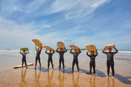 Téléchargez les photos : Un groupe de jeunes surfeurs dynamiques saisit un moment collectif avec leurs planches au bord de l'océan à Essaouira, au Maroc. La camaraderie de la culture surf sur fond de charme côtier pittoresque d'Essaouira - en image libre de droit