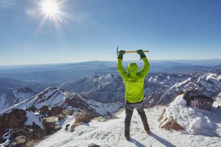 Photo for Alpinist standing at snow covered top of the peak of Jebel Toubkal in Atlas mountains Morocco - Royalty Free Image