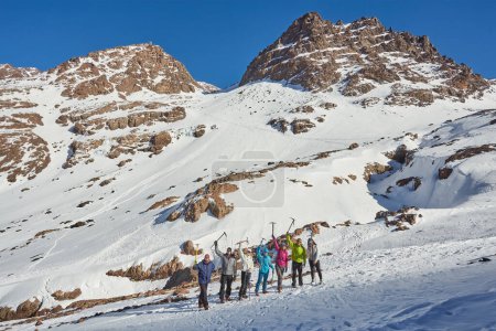Téléchargez les photos : Un groupe de touristes saisit un moment mémorable au sommet des montagnes de l'Atlas au Maroc, encadrant le cadre montagneux à couper le souffle - en image libre de droit
