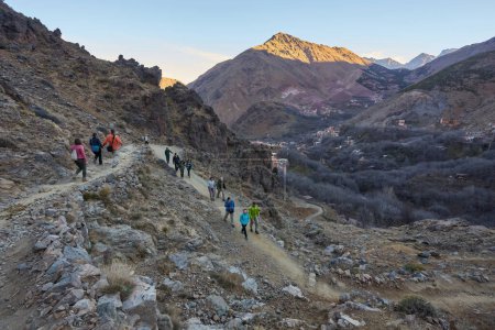 Foto de Un grupo de turistas recorriendo las impresionantes montañas del Atlas en Marruecos, abrazando la belleza del terreno accidentado y conectándose con la naturaleza - Imagen libre de derechos