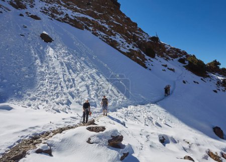 Téléchargez les photos : Un groupe de touristes trekking à travers les superbes montagnes de l'Atlas au Maroc, embrassant la beauté du terrain accidenté et se connectant avec la nature - en image libre de droit