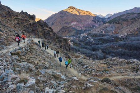Téléchargez les photos : Groupe de personnes avec de grands sacs à dos randonnée sur le mont Toubkal, Marocaine, en direction du sommet de la plus haute montagne de l'Atlas - en image libre de droit