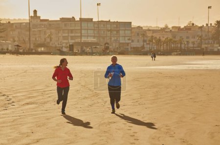 Foto de Dos jóvenes abrazan la tranquilidad de una carrera costera a lo largo del océano de Essaouira, donde las olas rítmicas crean un relajante telón de fondo para su vigorizante trote - Imagen libre de derechos