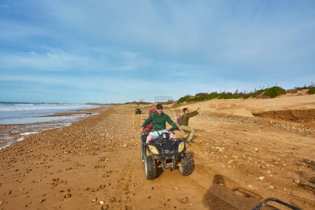 Photo for A group of tourists enjoys quad biking along Essaouira's oceanfront, creating an adventurous spectacle against the scenic coastal backdrop - Royalty Free Image