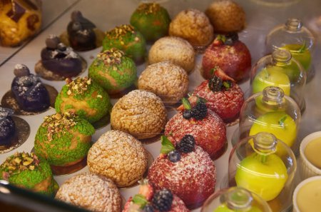 Photo for Pastry shop with variety of donuts, muffins, creme brulee, cakes with fruits and berries - Royalty Free Image