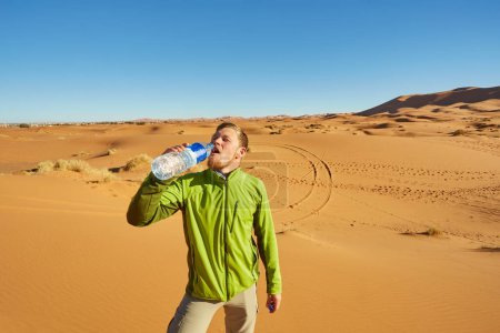 Foto de Un viajero solitario en el Sahara, cautivado por la vasta extensión de dunas doradas bajo el sol brillante - Imagen libre de derechos