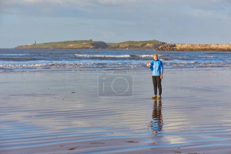 Photo for A young woman enjoying a coastal jog along Essaouira's oceanfront, with the Atlantic waves providing a serene backdrop to her invigorating run - Royalty Free Image
