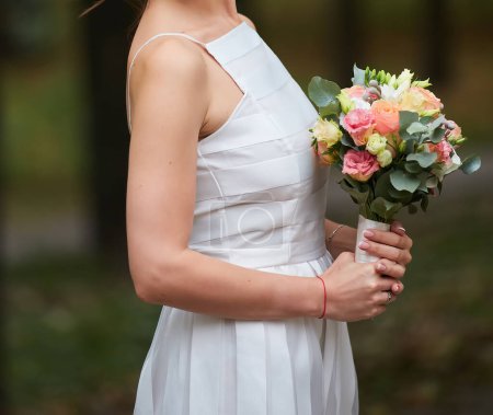 Téléchargez les photos : Des mains tendres bercent un bouquet nuptial, symbole d'amour et de beauté. - en image libre de droit