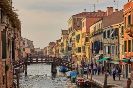 Foto de Venecia, Italia - 14 de octubre de 2018: hermosa arquitectura de Venecia, Italia con un pequeño puente sobre un canal iluminado por la luz de la calle - Imagen libre de derechos