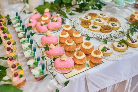 Photo for A variety of delicious desserts, cakes with cream, berries, whipped cream, marshmallows, festive decor, sweet bar, a treat. catering food. tasty dessert. Wedding banquet table. pastry on sweet buffet - Royalty Free Image