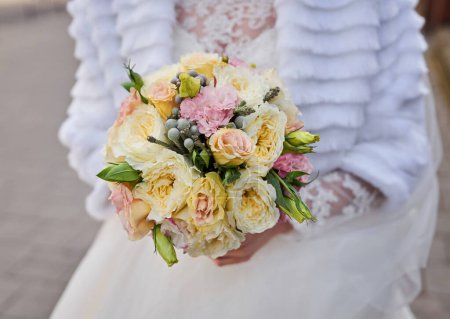 Téléchargez les photos : Mains gracieuses tenant le bouquet d'une mariée, mettant en valeur la beauté des fleurs de mariage. - en image libre de droit