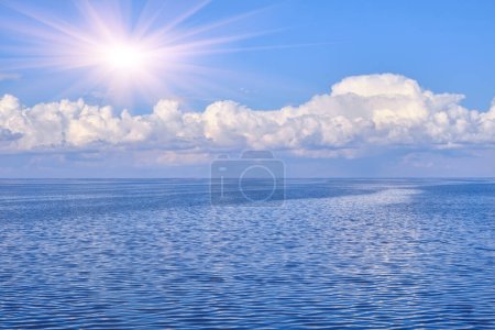 A tranquil seascape with gentle ripples on the water and billowy white clouds in the sky, their reflections dancing on the serene surface, creating a harmonious interplay of light and nature